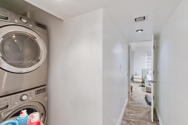 clothes washing area featuring stacked washer / dryer