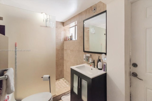 bathroom with tasteful backsplash, tile walls, vanity, tiled shower, and toilet