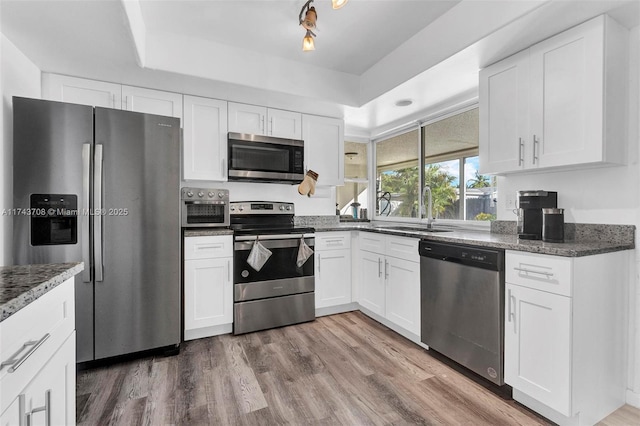 kitchen with appliances with stainless steel finishes, sink, and white cabinets