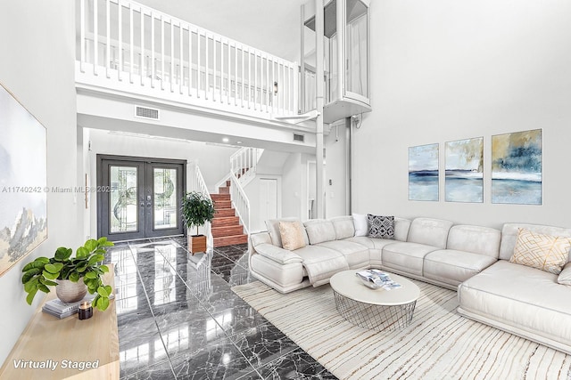 living room with a high ceiling and french doors