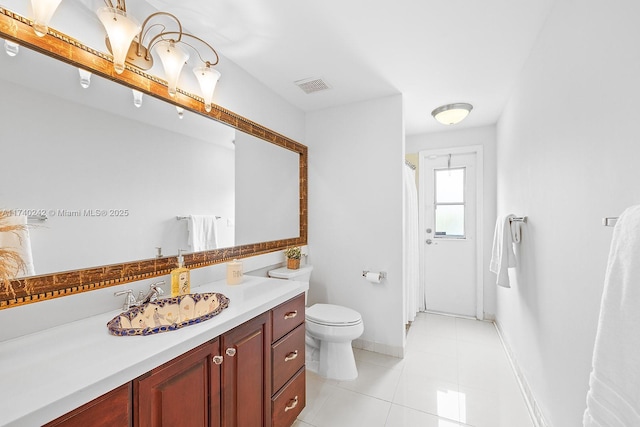 bathroom with vanity, tile patterned flooring, toilet, and walk in shower