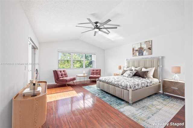 bedroom with a textured ceiling, lofted ceiling, ceiling fan, and wood-type flooring