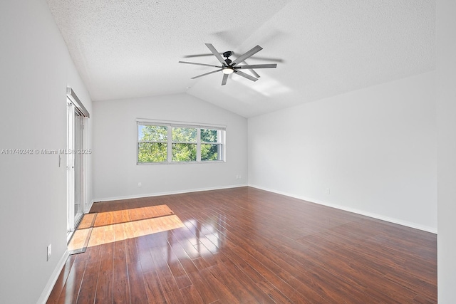 empty room featuring a textured ceiling, dark wood-type flooring, lofted ceiling, and ceiling fan