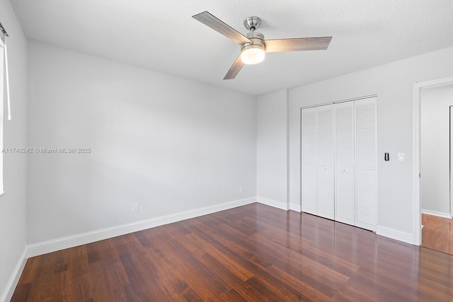 unfurnished bedroom featuring ceiling fan, dark hardwood / wood-style floors, a textured ceiling, and a closet