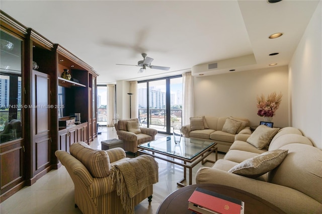 tiled living room featuring ceiling fan and a wall of windows