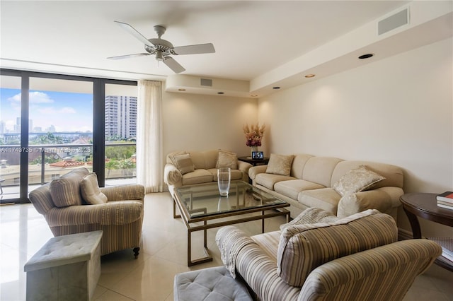 tiled living room with floor to ceiling windows and ceiling fan