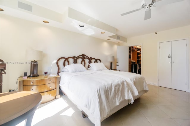 bedroom featuring ceiling fan, a spacious closet, a closet, and light tile patterned floors