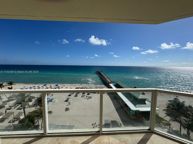 balcony featuring a view of the beach and a water view