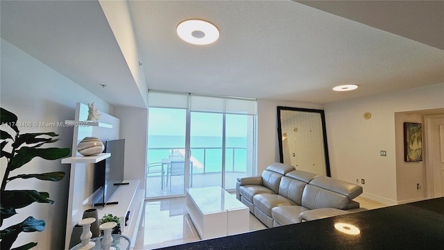 living room featuring a textured ceiling and a wall of windows