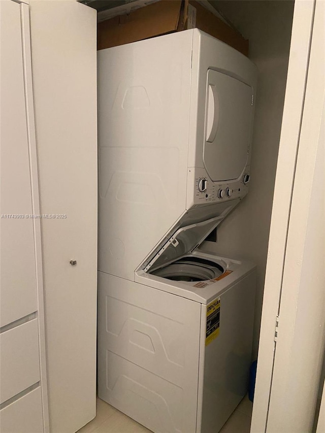 washroom featuring stacked washer and clothes dryer