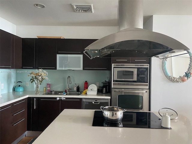 kitchen with tasteful backsplash, island exhaust hood, sink, and black appliances