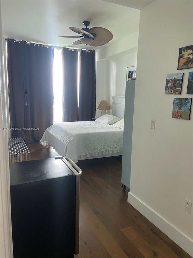 bedroom with dark hardwood / wood-style floors and ceiling fan