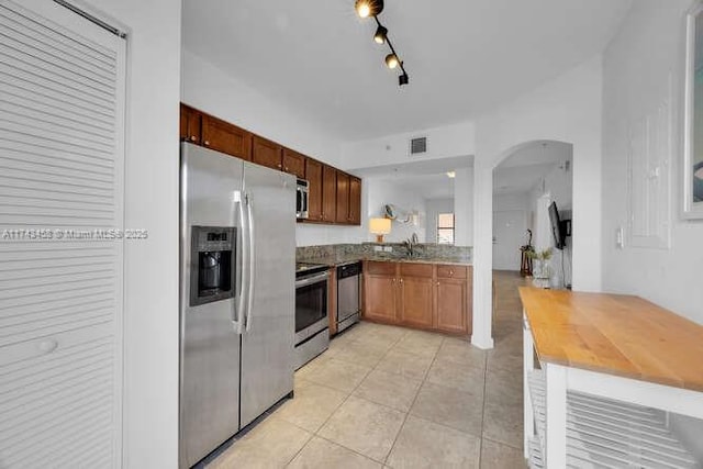 kitchen with light tile patterned flooring, track lighting, and appliances with stainless steel finishes