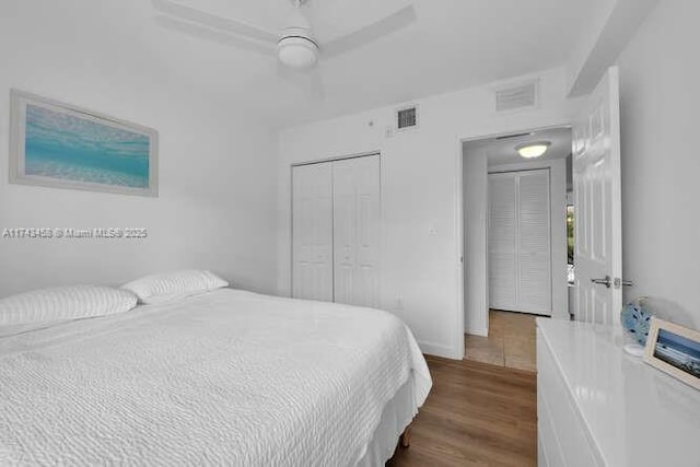 bedroom with dark hardwood / wood-style floors, ceiling fan, and a closet