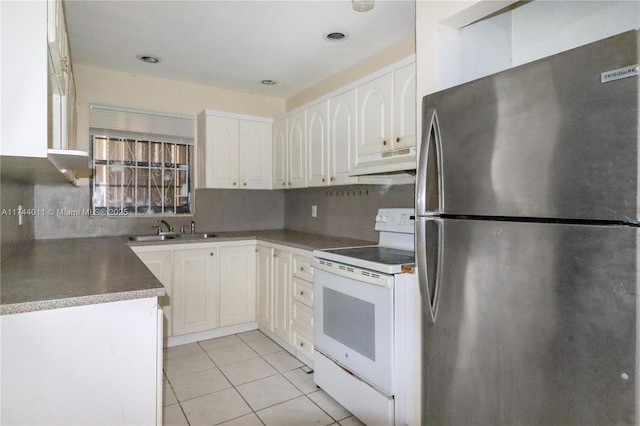 kitchen with sink, light tile patterned floors, stainless steel refrigerator, electric stove, and white cabinets