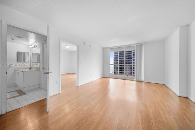 interior space with sink, a textured ceiling, and light hardwood / wood-style floors