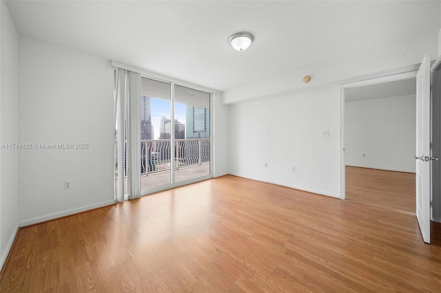 empty room featuring light wood-type flooring and expansive windows