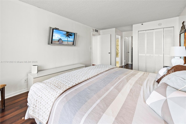 2555 Collins Ave Unit 403, Miami Beach, FL 33140 - bedroom with dark wood-type flooring, a closet, a textured ceiling, and baseboards