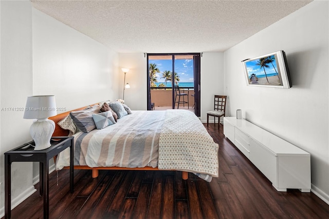 2555 Collins Ave Unit 403, Miami Beach, FL 33140 - bedroom featuring a textured ceiling, access to exterior, wood finished floors, and baseboards