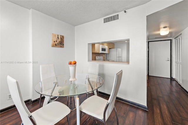 2555 Collins Ave Unit 403, Miami Beach, FL 33140 - dining room featuring hardwood / wood-style floors, baseboards, and a textured ceiling