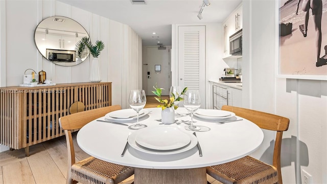 dining space featuring light hardwood / wood-style flooring and rail lighting