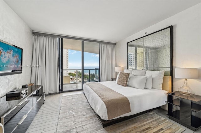 2201 Collins Ave Unit 811, Miami Beach, FL 33139 - bedroom featuring access to outside, floor to ceiling windows, wood finished floors, and a water view