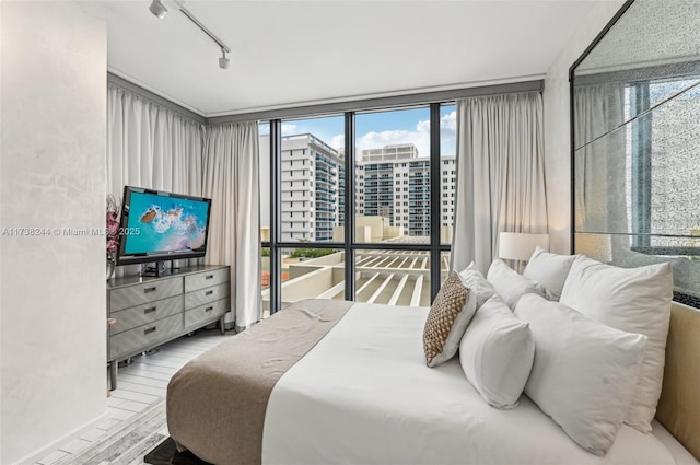 2201 Collins Ave Unit 811, Miami Beach, FL 33139 - bedroom featuring wood finished floors, track lighting, and floor to ceiling windows