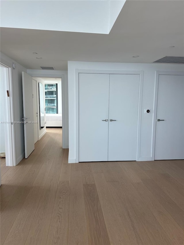 corridor with light hardwood / wood-style floors