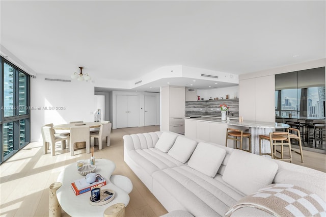 living area featuring light wood-style floors, a wealth of natural light, and floor to ceiling windows