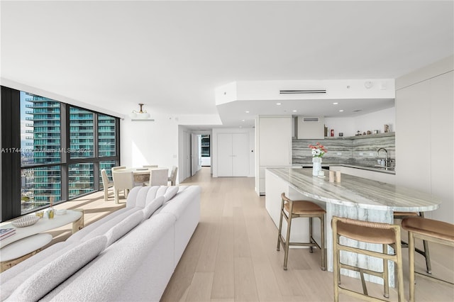 living area featuring light wood-style floors, expansive windows, and recessed lighting