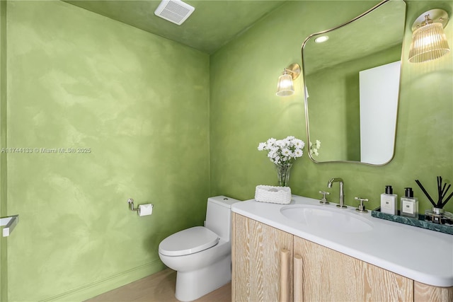 bathroom featuring toilet, visible vents, and vanity