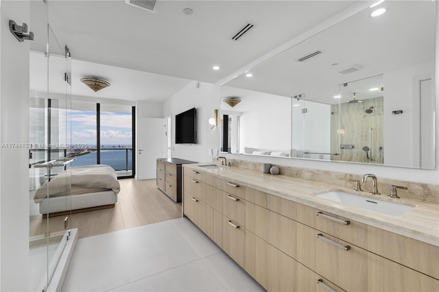 full bath with double vanity, a stall shower, a sink, and visible vents