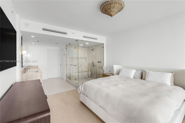 bedroom with recessed lighting, a sink, and wood finished floors