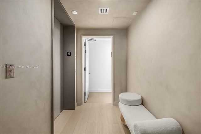 hall featuring light wood finished floors and visible vents