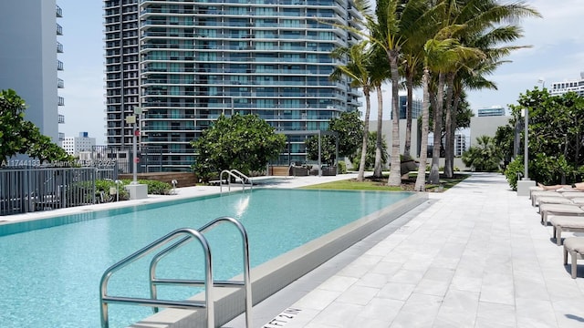 pool with fence and a city view