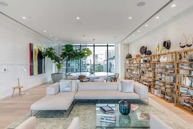 living room with a wall of windows, wood finished floors, and recessed lighting