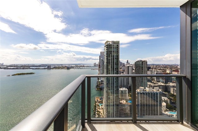 balcony with a water view and a view of city