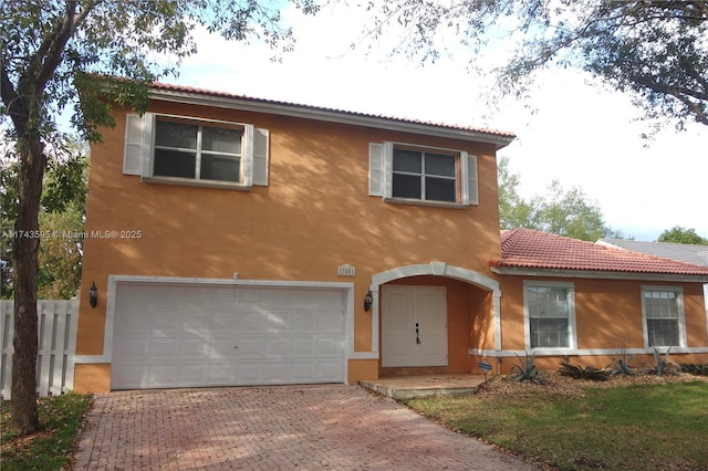 view of front of home with stucco siding, an attached garage, decorative driveway, and fence