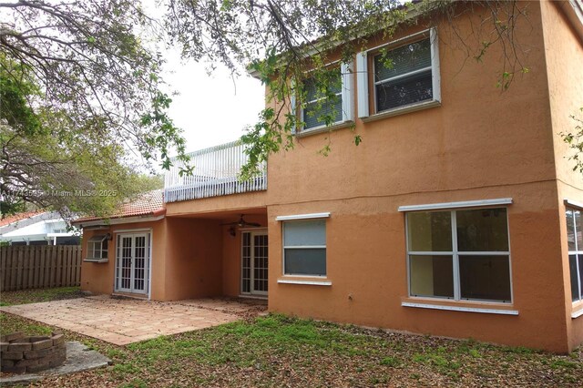 back of house featuring a tile roof, stucco siding, a patio area, ceiling fan, and fence