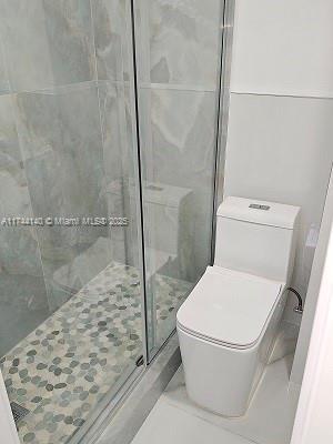 bathroom with walk in shower and toilet