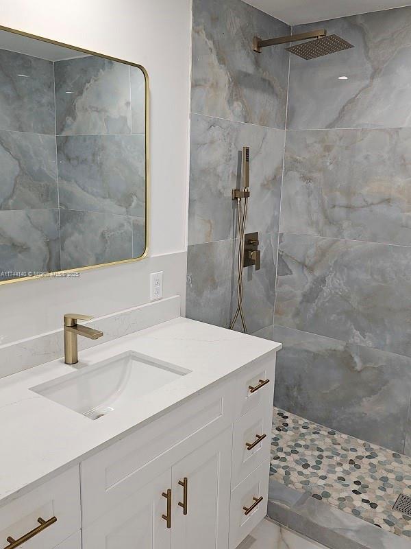 bathroom featuring vanity and a tile shower