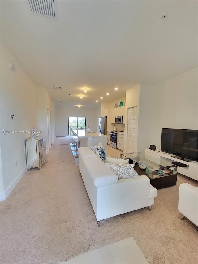 carpeted living room featuring sink