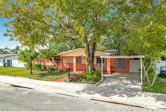 ranch-style home featuring a carport and a front yard