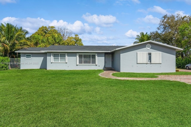 ranch-style house featuring a front lawn and stucco siding