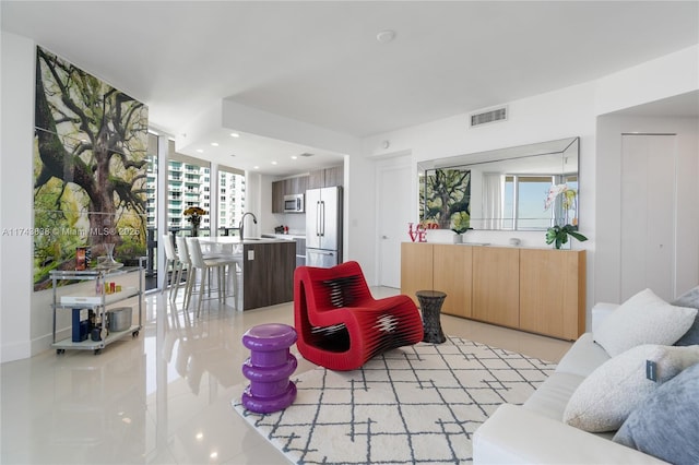 tiled living room with sink and expansive windows