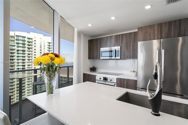 kitchen with dark brown cabinets and appliances with stainless steel finishes