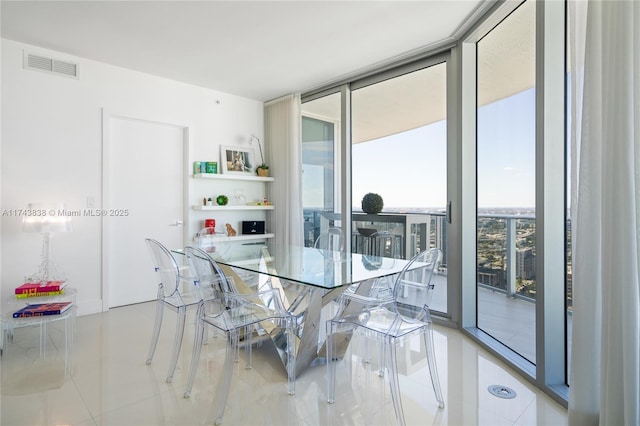 dining space featuring expansive windows and light tile patterned flooring