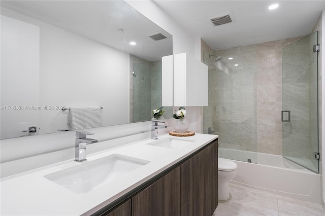 full bathroom featuring bath / shower combo with glass door, vanity, and toilet