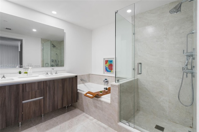 bathroom featuring vanity and independent shower and bath