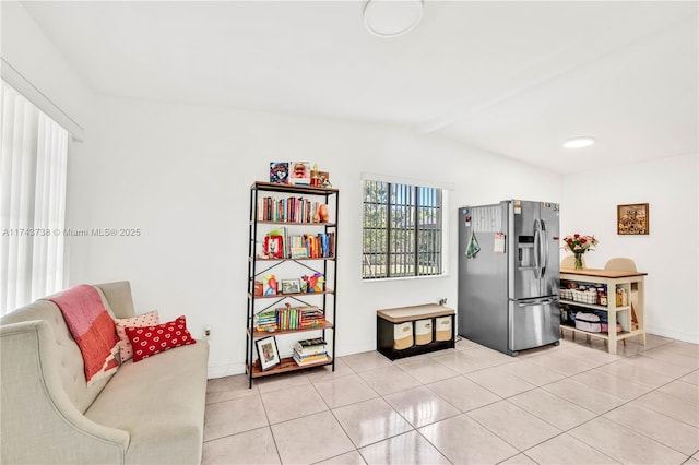 kitchen featuring stainless steel refrigerator with ice dispenser, vaulted ceiling with beams, and light tile patterned floors